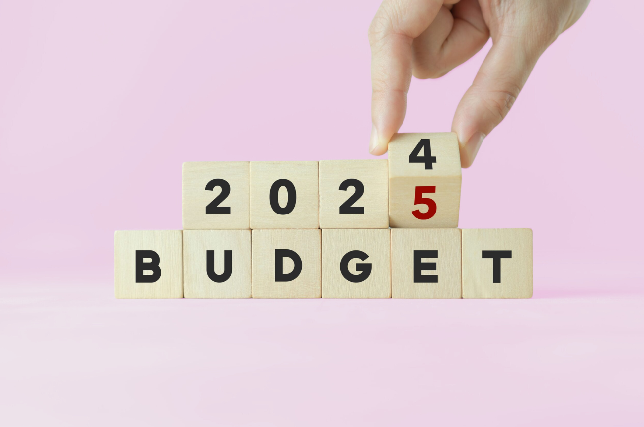 Wooden blocks that spell out "2024 budget" with a hand changing the 4 to a 5, representing 2025 Budget Planning for Employer Branding